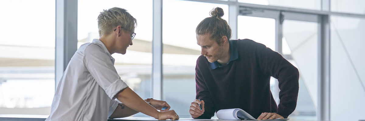 two people looking at paper on table