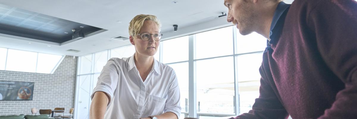 A male and female colleague talking to each other