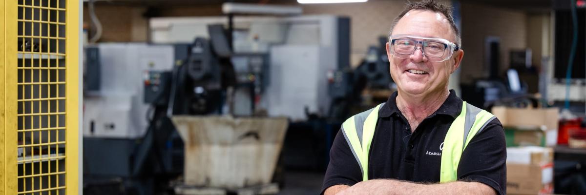 Man smiling with his arms folder in a warehouse