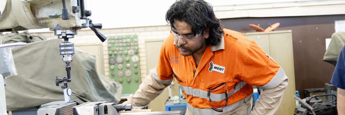 Fitting apprentice looking at machine