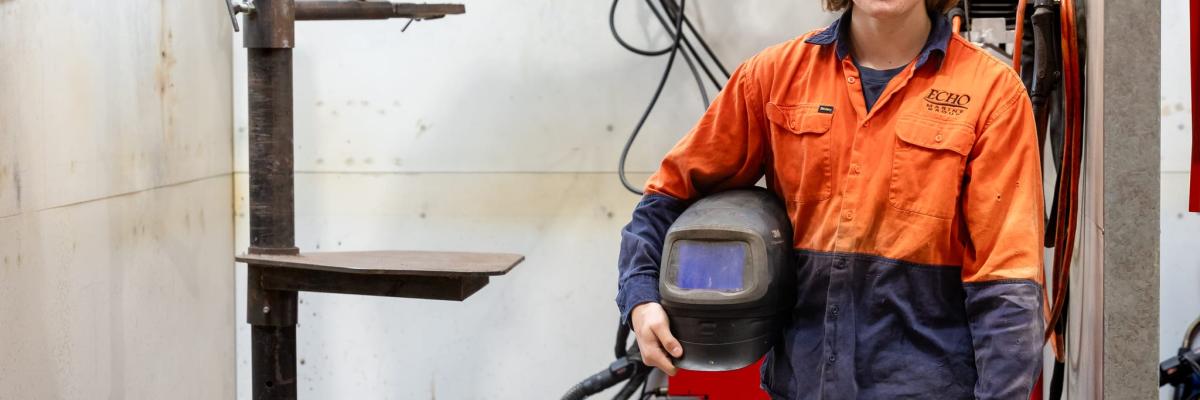 boiler maker holding helmet and smiling at the camera