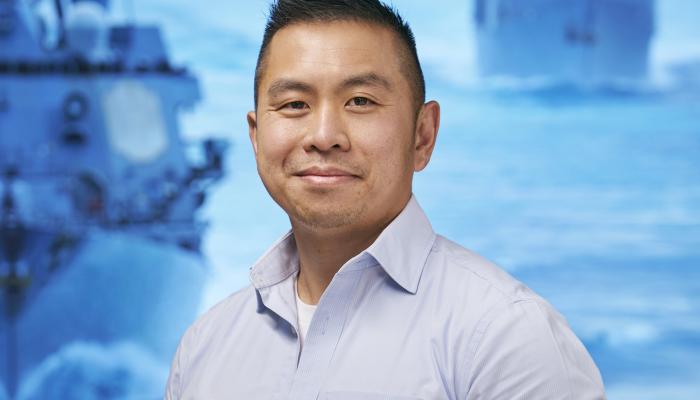 Person standing in front of screen with ships