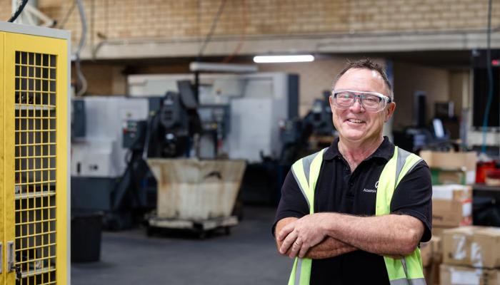 Man smiling with his arms folder in a warehouse