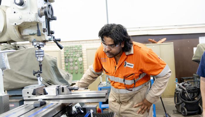 Fitting apprentice looking at machine