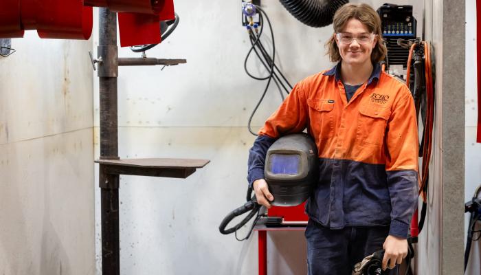 boiler maker holding helmet and smiling at the camera
