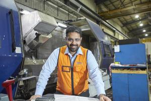 Hofmann Engineering employee smiling and holding CAD drawings