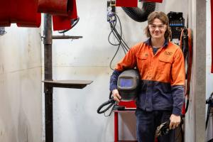 boiler maker holding helmet and smiling at the camera
